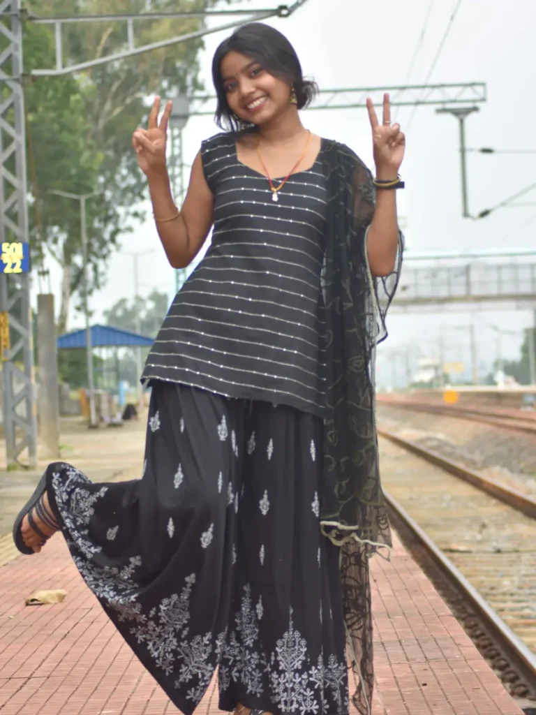 Anupama cute expression holding hand on face sitting outdoors